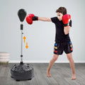 Free-standing adjustable punching bag with rebound spring